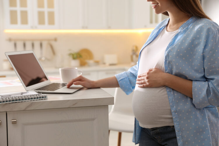 Pregnant woman working in kitchen at home, closeup. Maternity le Pregnancy and Parental Leave in NJ: Ensuring Equal Treatment and Fair Accommodation