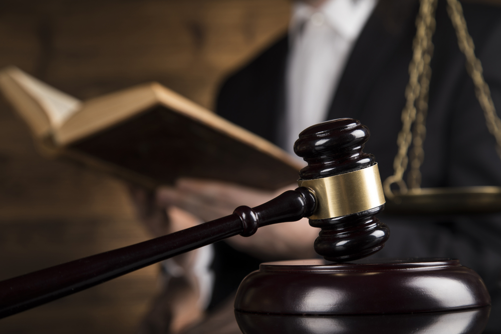 Close-up of a judge's gavel with legal scales in the background, representing legal action for wage and hour law violations.