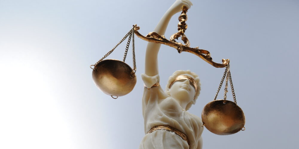 A statue of Lady Justice holding scales, symbolizing fairness and the enforcement of wage and hour laws in New Jersey.